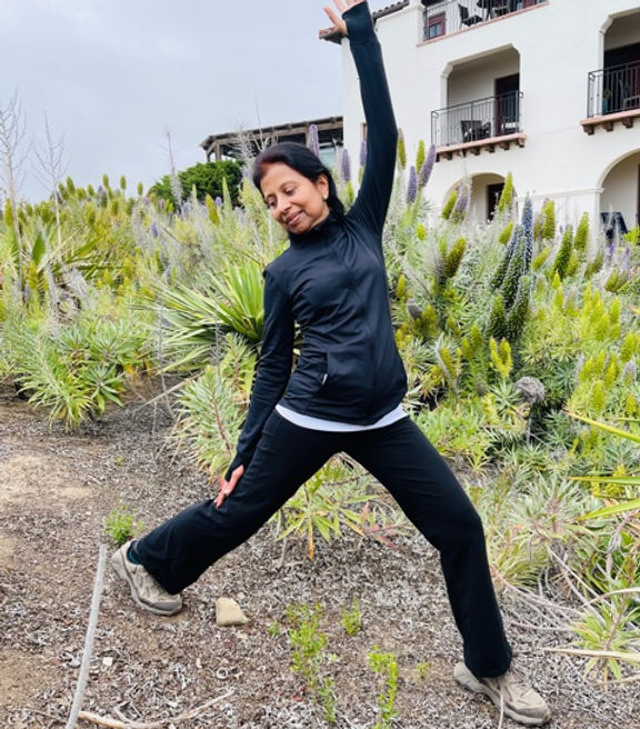 Priya Kasturi outdoors in a wide-legged standing pose